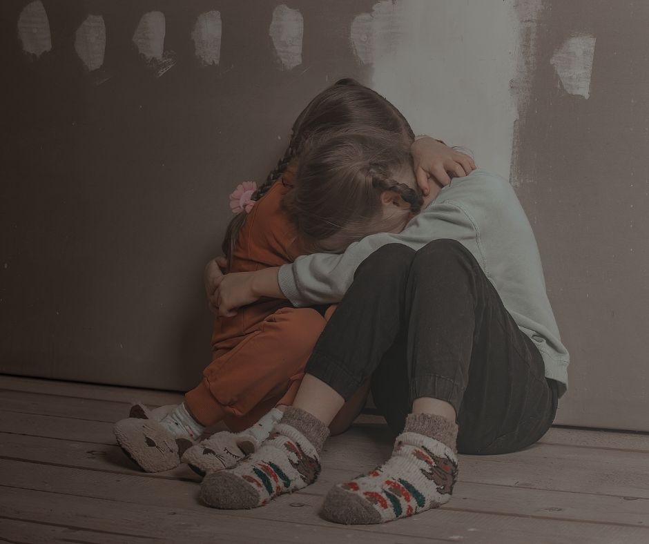 Des enfants effrayés se serrent les uns contre les autres.