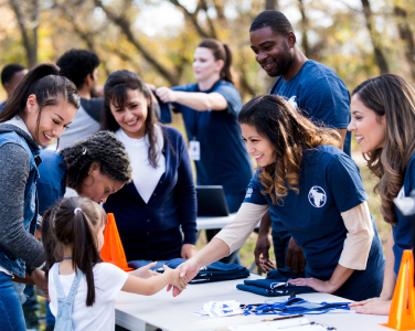 volunteers shaking hands with a kid