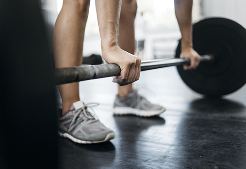 mains saisissant une barre à disques