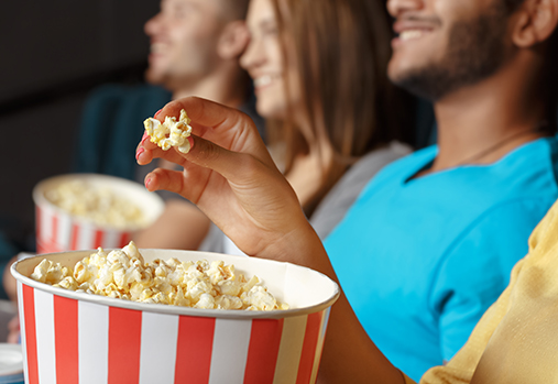 personnes mangeant du pop-corn au cinéma