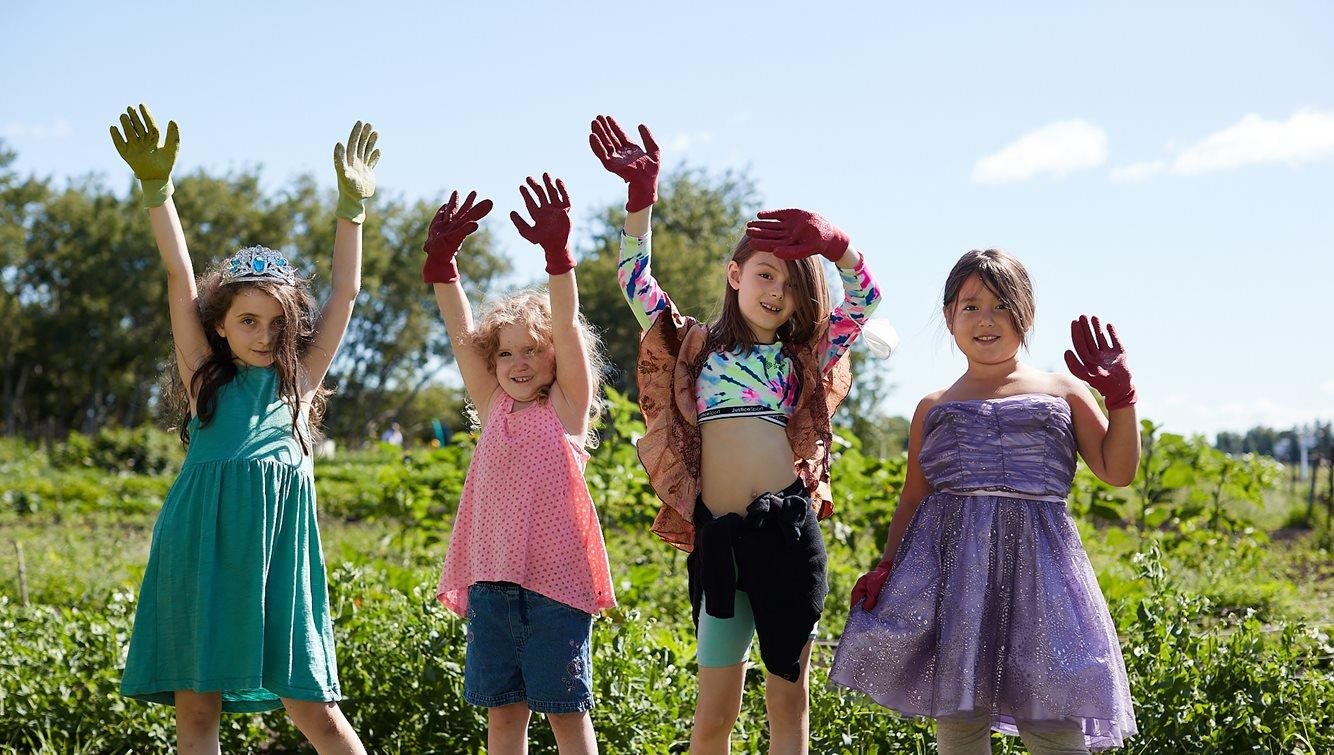 Four Summer Camp participants out at the community garden