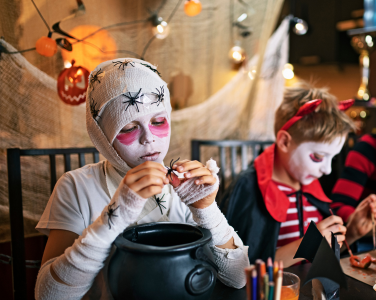Un enfant déguisé en momie dans un décor sur le thème d'Halloween.