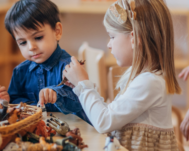 Des enfants jouent autour d'une table avec des jouets d'animaux.