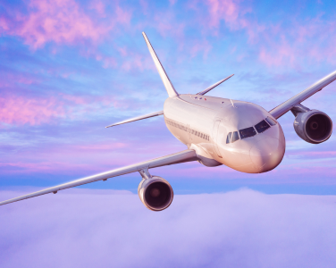 Avion volant dans un ciel rose et violet.