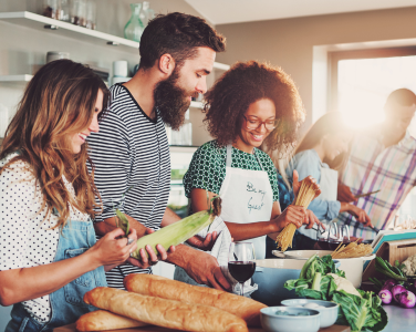 Des adultes qui préparent un repas ensemble dans une cuisine.