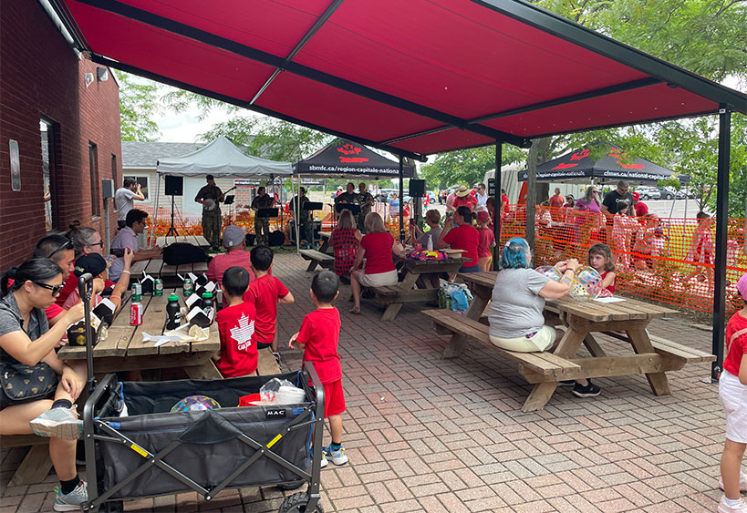 Famille heureuse, pique-nique et été, plaisir dans un parc avec des enfants et des parents se rapprochant et jouant sur l'herbe.