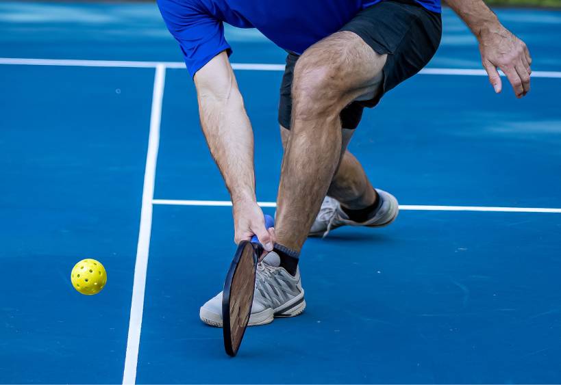 Homme jouant au pickleball en salle