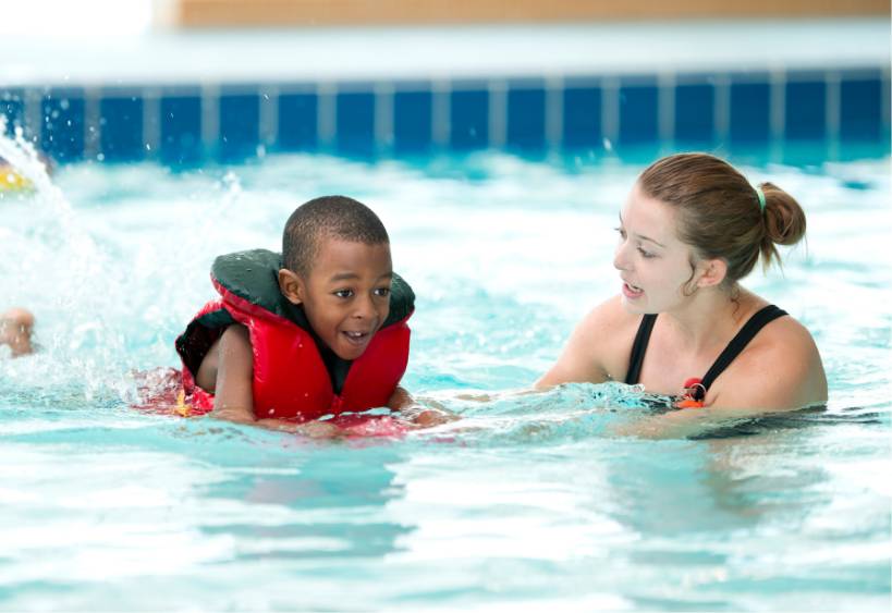 Enfant et instructeur dans un cours de natation