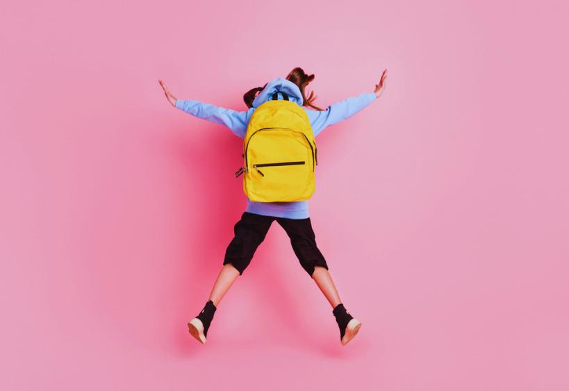 Vue de dos d’une fille portant un sac à dos et en train de sauter