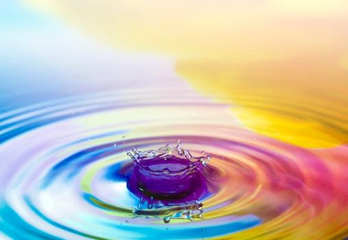 Une goutte d’eau qui tombe dans une eau ondulée et colorée