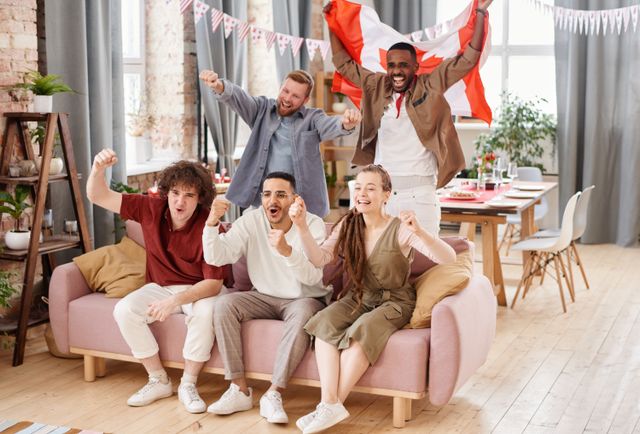 Groupe d’ami·e·s qui célèbrent à l’intérieur, avec un drapeau canadien, partageant un moment animé ensemble.