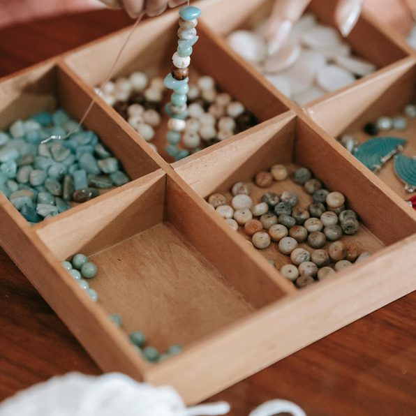 plateau en bois avec un assortiment de perles pour la fabrication de bijoux 