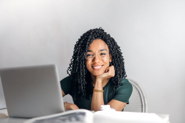 femme assise à un bureau et souriante