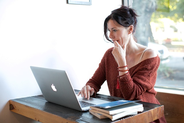 Femme assise à un bureau regardant son ordinateur portable