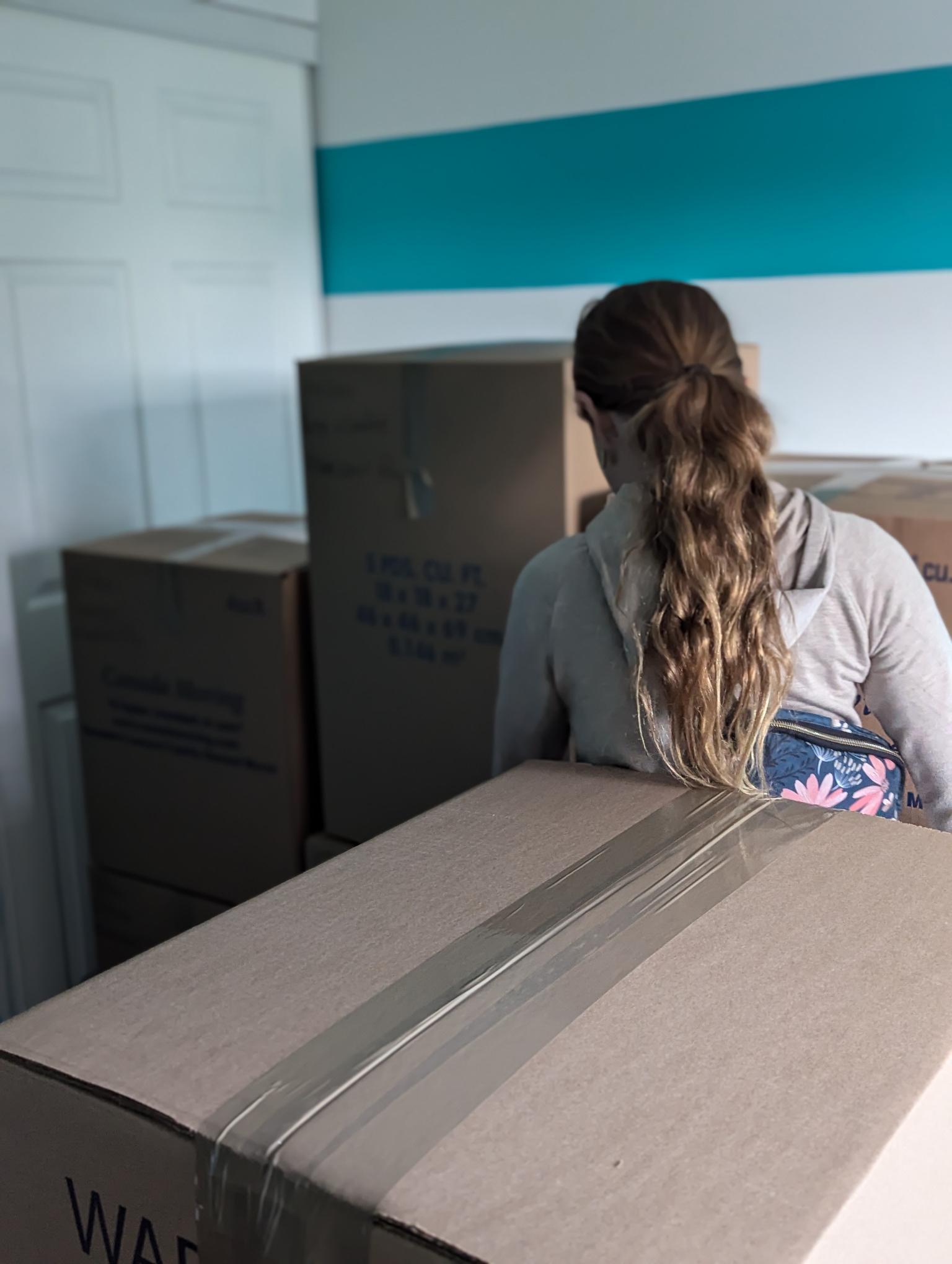 fille debout au milieu de cartons