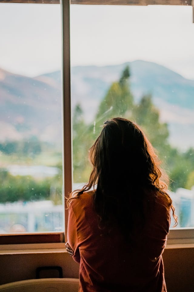 femme regardant par la fenêtre