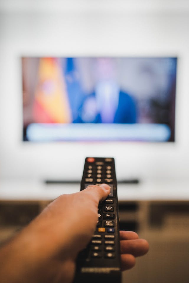 Personne tenant une télécommande noire