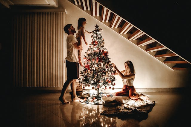 Une famille en train de décorer son sapin de Noël
