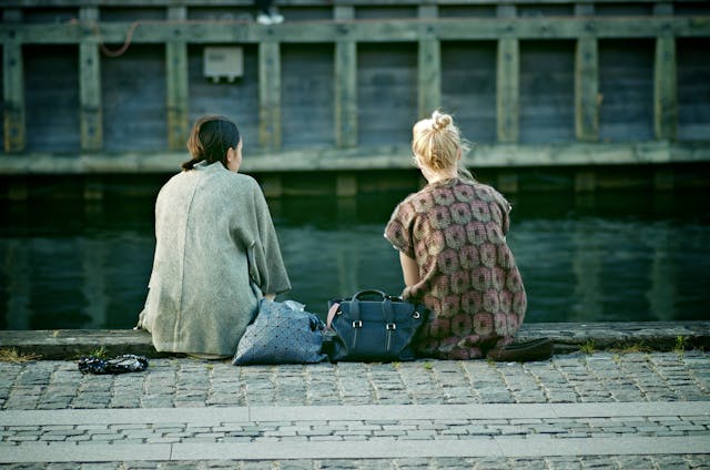 Vue de dos de deux femmes assises sur le front de mer à Copenhague, au Danemark