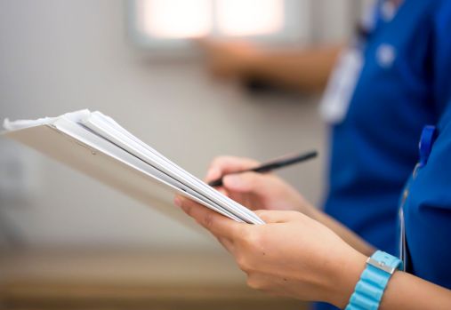 personne tenant un papier et un stylo