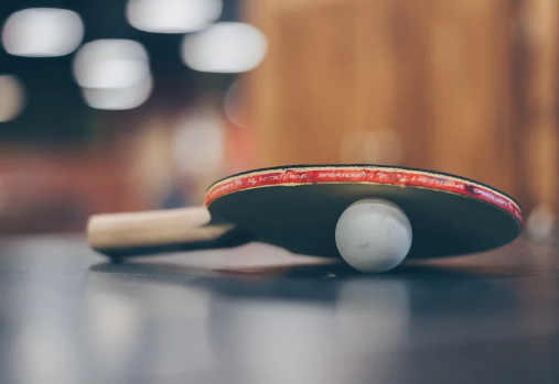 une raquette de ping-pong posée sur une balle de ping-pong