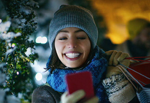 femme portant des paquets, regardant son téléphone portable