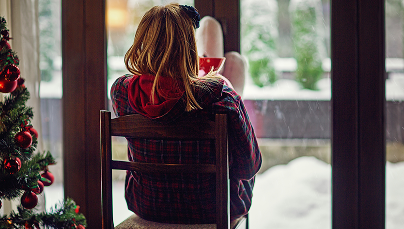 woman looking out window during holiday