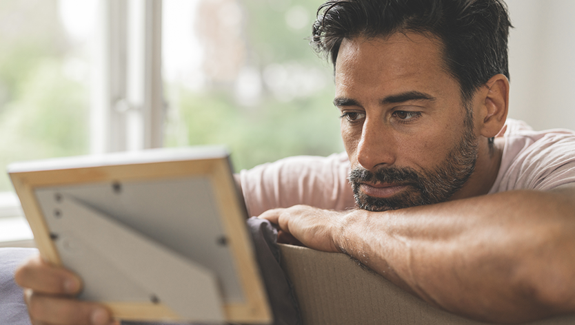 man looking at picture in frame