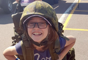 petite fille portant un casque militaire canadien