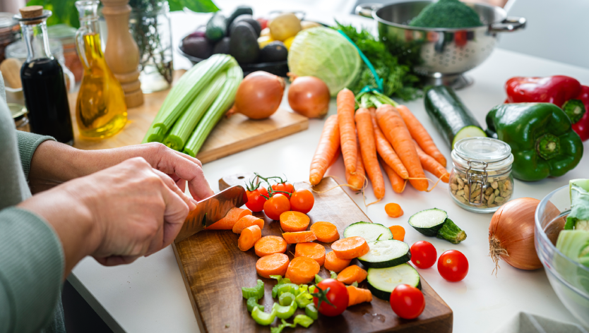 Des mains qui coupent des légumes 
