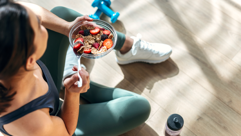 Une femme qui s'entraine et qui tient un bol d'aliments sain