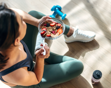 Une femme qui s'entraine et qui tient un bol d'aliments sain