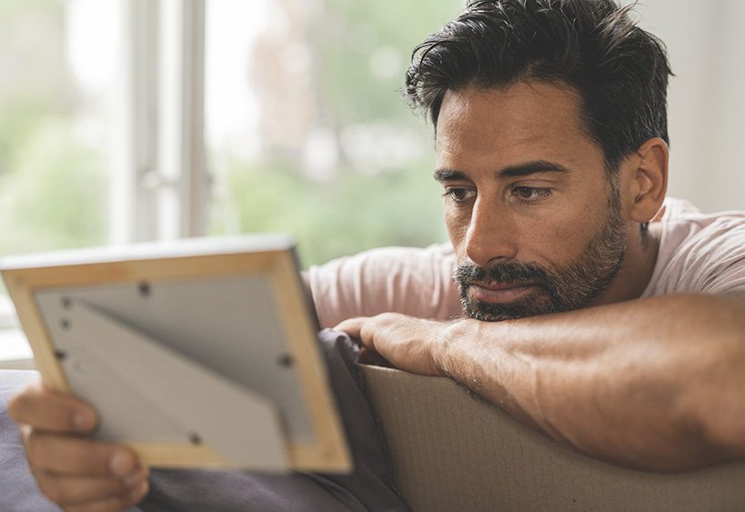 man staring at picture in frame