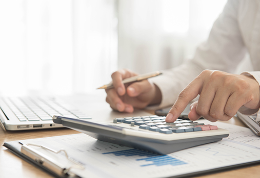 une personne qui fait un budget avec une calculatrice