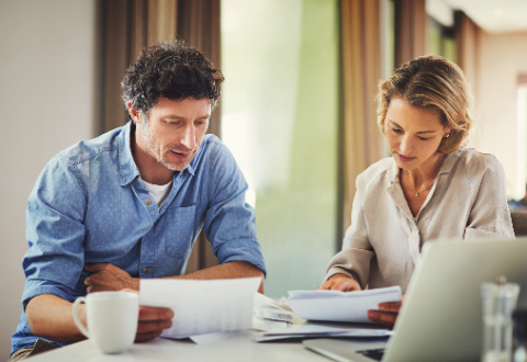 un homme et une femme qui regarde des papiers financiers