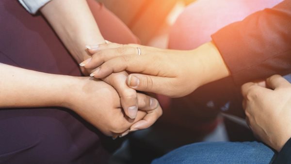 des personnes se tenant la main en signe de soutien.