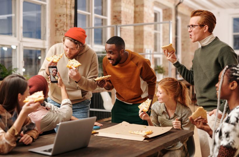 des adultes en train de manger de la pizza