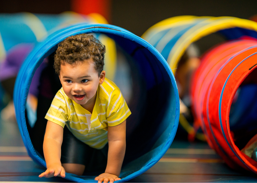 Enfant rampant à travers un jouet